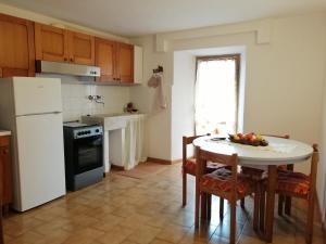 a kitchen with a table and a white refrigerator at La casa di Piera in Riccò del Golfo di Spezia