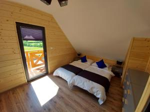 a bedroom with a bed and a large window at Osada Orlica 3 in Lasowka