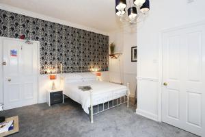 a bedroom with a bed and a black and white wallpaper at The Bishop and The Bison in York