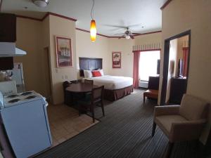 コーパスクリスティにあるHawthorn Extended Stay by Wyndham Corpus Christi Padre Isleのベッドとテーブルのあるホテルの部屋 +25枚の写真