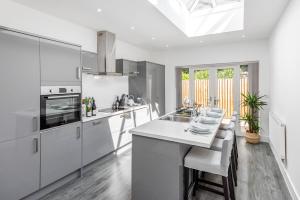 een keuken met witte kasten en een wit aanrecht bij Relax in Stunning Pontcanna Apartment Close To City Centre in Cardiff