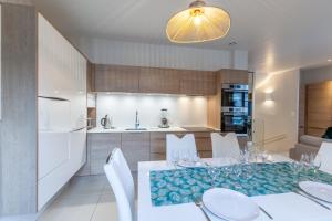 cocina y comedor con mesa y sillas en Beau duplex - Haut de gamme Place Morny - 75m2, en Deauville