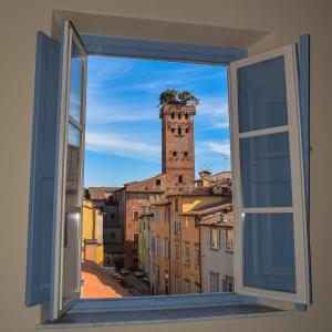 une fenêtre ouverte avec vue sur une tour dans l'établissement Al Carmine Apartments Towers view with AC, à Lucques