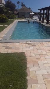 a swimming pool with blue water and a patio at WATER FRONT in Maceió