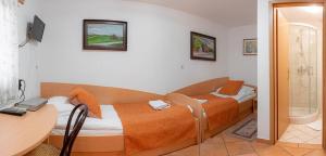a bedroom with two beds and a desk and a table at Hotel Gostilna Vovko in Novo Mesto