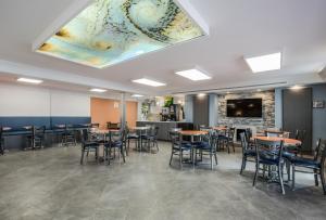 Quality Inn في هامبتون: غرفة طعام مع طاولات وكراسي وتلفزيون