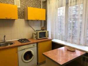 a kitchen with a washing machine and a microwave at Kyiv daily rent Apartments on Bogdana Gavrilishina 10 in Kyiv