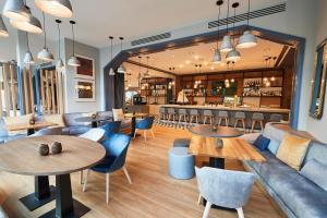 a restaurant with tables and chairs and a bar at Steigenberger Conti Hansa in Kiel