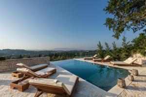 una piscina con tumbonas y una piscina en Villa Magnolia Corfu, en Perama