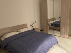 1 dormitorio con cama azul y espejo en la nostra casa... en Novara
