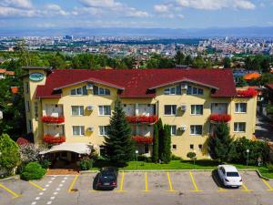 a large building with cars parked in a parking lot at Jasmin Hotel in Sofia