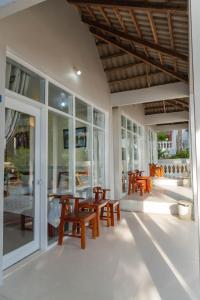 un patio con mesas y sillas de madera y ventanas en Nhat Lan Resort, en Phu Quoc