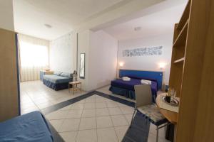 pokój hotelowy z 2 łóżkami i stołem w obiekcie Lewis Rooms Poetto Beach w Cagliari