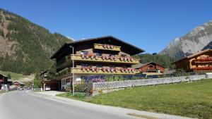 un edificio con gente en los balcones en una carretera en Ferienhaus Tirolerhof en Kals am Großglockner