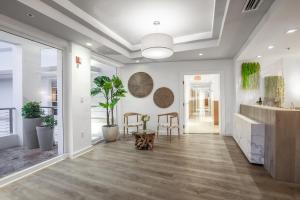 un soggiorno con pareti bianche e pavimenti in legno di Bentley Hotel South Beach a Miami Beach