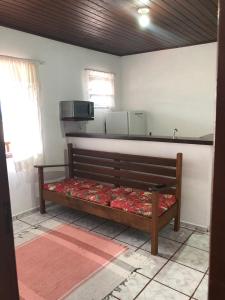 un banco de madera en una habitación con TV en Chalé do Radiola, en Ilhabela