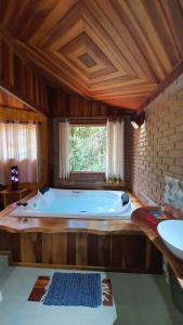 uma grande banheira num quarto com uma janela em Chale Truta da Floresta 2 em Viscode de Mauá