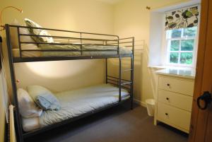a bedroom with two bunk beds and a window at Mauldslie Hill Cottage in Gorebridge