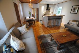 uma sala de estar com um sofá e uma mesa em Mauldslie Hill Cottage em Gorebridge
