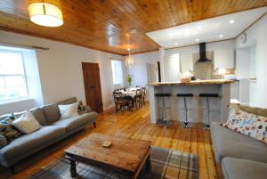 a living room with a couch and a table at Mauldslie Hill Cottage in Gorebridge