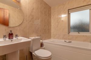 a bathroom with a white toilet and a sink at Beachview Holiday Flat 2 in Lossiemouth +15 photos