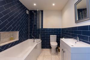 a bathroom with a tub and a toilet and a sink at Stunning Shore Front house in historic Cellardyke in Anstruther