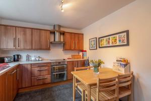 a kitchen with wooden cabinets and a wooden table at Beachview Holiday Flat 2 in Lossiemouth