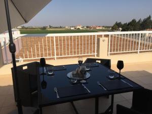 a table with wine glasses and an umbrella on a balcony at Beautiful spacious 2-Bed Apartment in Xylofagou in Xylophaghou