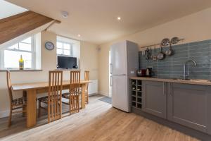a kitchen with a table and a refrigerator at Stunning Shore Front house in historic Cellardyke in Anstruther