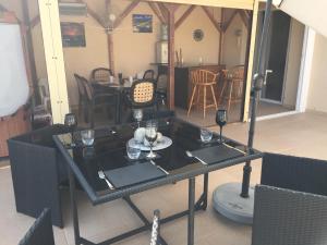 a black table with wine glasses on top of it at 2 Bed Flat - Sleeps 4 - Pool - Parking - Wifi in Xylophaghou +6 photos