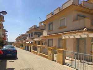 um carro estacionado numa rua ao lado de uma fila de casas em Beautiful Villa in Murcia with pool just 10m away em Múrcia