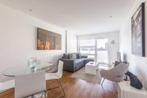 a white living room with a table and a couch at Luxury 2-Bed Flat parking and close to the tube in London