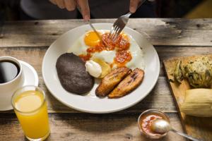 um prato de comida de pequeno-almoço numa mesa de madeira em Hotel San Jorge by Porta Hotels em Antigua Guatemala