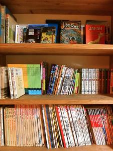 a book shelf filled with lots of books at 4Bed Family Room Aosh ima Guesthouse Hooju Vacation STAY 13477v in Miyazaki
