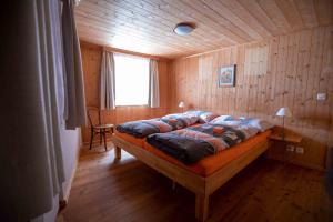 1 dormitorio con 1 cama en una habitación de madera en Alpensonne, en Reckingen - Gluringen