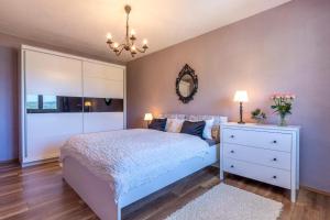 a bedroom with a white bed and a mirror at Apartman ELLA in Peračko Blato