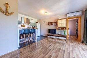 a living room with a kitchen and two bar stools at Apartman ELLA in Peračko Blato +41 photos