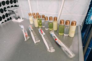 a counter with bottles of toothbrushes and toothpaste at Просторная квартира для большой компании в центре Павлодара in Pavlodar +18 photos