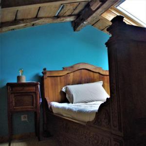 a bedroom with a bed with a wooden frame and a window at Le vieux pont in Saint-Julien