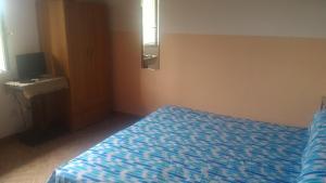 - une chambre avec un lit et une couette bleue dans l'établissement Michelangelo's House, à Gioiosa Marea