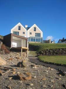 a house on a hill with a gravel driveway at At The Beach Rooms in Portstewart