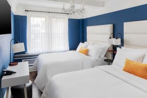 um quarto com 2 camas e paredes azuis em voco The Franklin New York, an IHG Hotel em Nova York