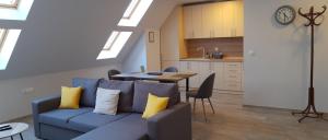 a living room with a blue couch and a kitchen at Sky Blue Danube Apartment Ruse in Ruse