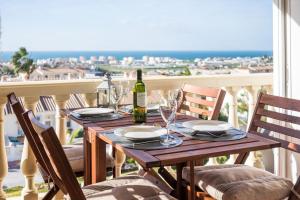 a table with glasses and a bottle of wine on a balcony at Residentie Montesol in Torrox