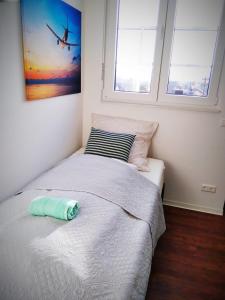 a bed in a bedroom with two windows at Sroom Stuttgart Flughafen Messe in Leinfelden-Echterdingen