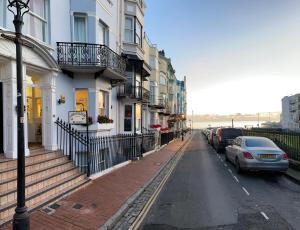 una strada con edifici e auto parcheggiati sulla strada di Ambassador Hotel a Brighton & Hove