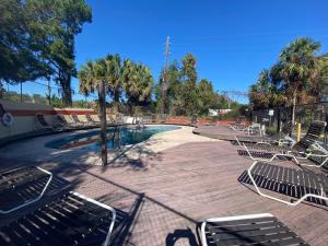 un grupo de sillas sentadas alrededor de una piscina en Americas Best Value Inn - Gainesville, en Gainesville