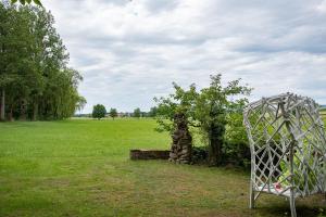 a chair in a field with a tree and a goal at Moulin de Schwabwiller in Schwabwiller