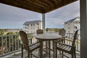 a porch with a table and chairs on a balcony at Hwy 12 Slash Creek in Hatteras