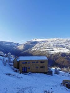 un bâtiment dans la neige sur une colline dans l'établissement Cabana Berg, à Someşu Rece